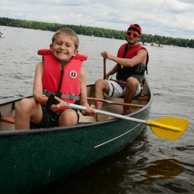 Camper and Counsellor paddling a canoe