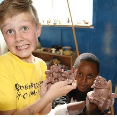 Boys with ADHD and autism showing off the pottery they made